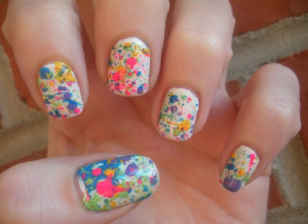white nails with colorful paint splatter designs 