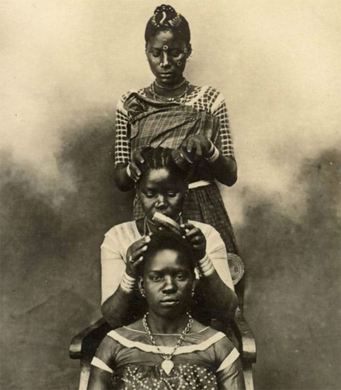 old image of three women braiding each others hair