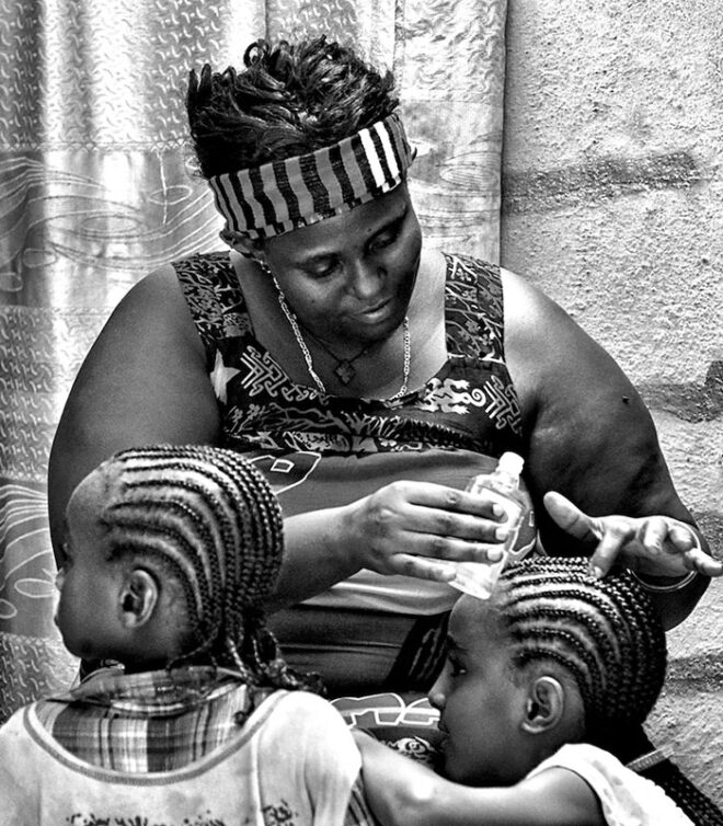 woman oiling childrens braids
