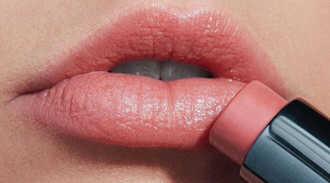 makeup kit essentials woman applying pink lipstick
