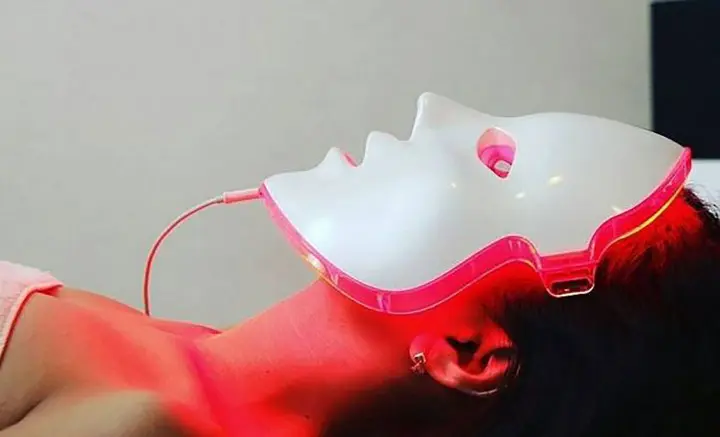person relaxing wearing LED mask
