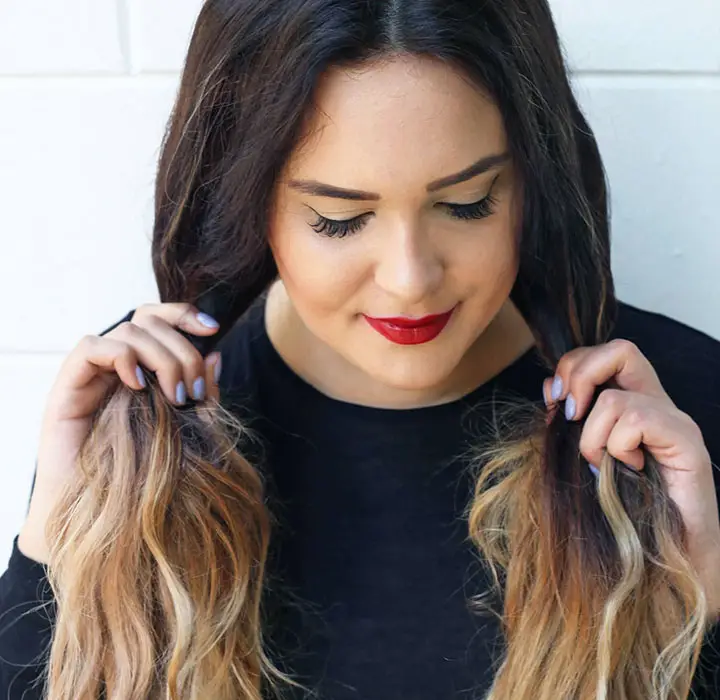 woman parting her hair into two sections for curling jpg