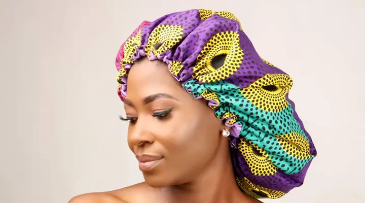 woman wearing a satin hair bonnet for jumbo box braids protection