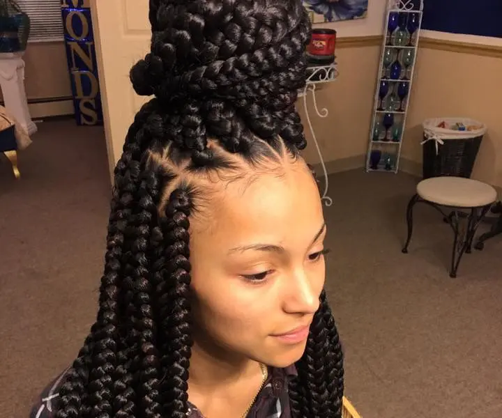 woman with jumbo box braids top knot style