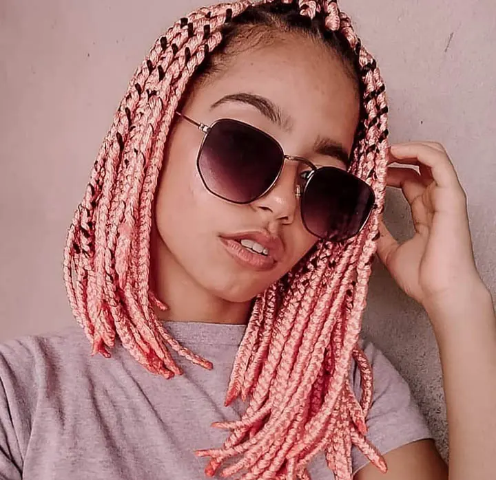woman with short pink jumbo box braids