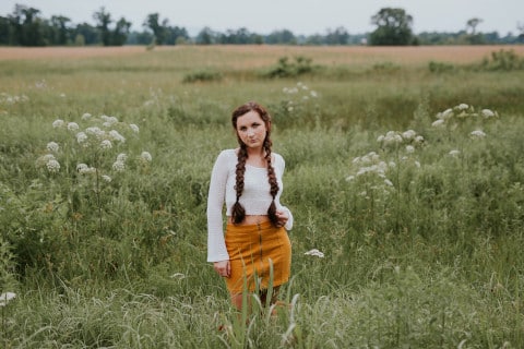 girl with braids in green field