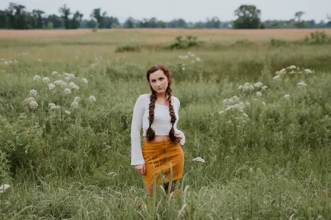 girl with braids in green field