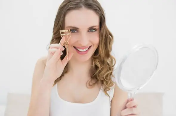 woman using an eyelash curler