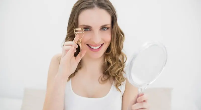 woman using an eyelash curler